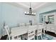 Bright dining room with white table, chandelier, and built-in hutch at 6843 Boulder Run Loop, Wesley Chapel, FL 33545