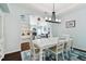 Dining room with white table, chandelier, and view into living room at 6843 Boulder Run Loop, Wesley Chapel, FL 33545