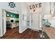 Bright entryway with wood floors, coat rack, and view of home office at 6843 Boulder Run Loop, Wesley Chapel, FL 33545