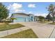 Exterior view of a charming light blue house with a large driveway at 6843 Boulder Run Loop, Wesley Chapel, FL 33545