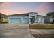 Cute light blue house with a two-car garage and manicured lawn at 6843 Boulder Run Loop, Wesley Chapel, FL 33545