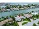 Aerial view of waterfront home with private dock and lush landscaping at 221 Howard Dr, Belleair Beach, FL 33786