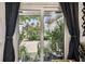 View of a lush, private backyard oasis through sliding glass doors at 221 Howard Dr, Belleair Beach, FL 33786