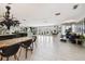 Open concept living and dining area with large island and statement chandelier at 221 Howard Dr, Belleair Beach, FL 33786