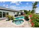 Stunning pool and spa with a spacious patio and tropical plants at 221 Howard Dr, Belleair Beach, FL 33786