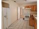 A galley-style kitchen with white appliances and wood cabinets at 304 E Hanlon St, Tampa, FL 33604