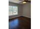 Bright bedroom featuring dark wood floors, ceiling fan and a large window for natural light at 277 Valencia Cir, St Petersburg, FL 33716