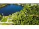 Aerial view showing house, pool, and lush green landscape near lake at 17210 Orangewood Dr, Lutz, FL 33548