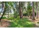 Landscaped backyard with lake access, hammock, and seating area at 17210 Orangewood Dr, Lutz, FL 33548