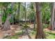 Secluded backyard oasis with brick path leading to home, surrounded by lush trees at 17210 Orangewood Dr, Lutz, FL 33548