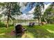 Lakefront backyard with firepit, chairs, and private dock access at 17210 Orangewood Dr, Lutz, FL 33548