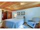 Charming bedroom with a wooden ceiling, comfortable bed, and an armchair at 17210 Orangewood Dr, Lutz, FL 33548