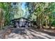 House exterior with a two-car garage and paved driveway surrounded by trees at 17210 Orangewood Dr, Lutz, FL 33548