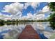 Serene lake view with a wooden dock extending into the water at 17210 Orangewood Dr, Lutz, FL 33548