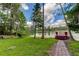 Peaceful lakefront property with dock, lush lawn, and relaxing seating area at 17210 Orangewood Dr, Lutz, FL 33548