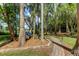 Brick pathway winds through a wooded area to a hammock by the lake at 17210 Orangewood Dr, Lutz, FL 33548