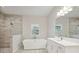 Modern bathroom with soaking tub, walk-in shower, and tiled floors at 6257 Hidden Branch Dr, Apollo Beach, FL 33572