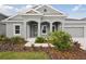 Gray house with two-car garage, walkway, and landscaping at 6257 Hidden Branch Dr, Apollo Beach, FL 33572