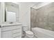 Bathroom with white vanity, single sink, and gray tile bathtub surround at 10536 Hidden Banks Gln, Parrish, FL 34219