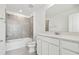 Bathroom with white vanity, tub and gray tile at 10536 Hidden Banks Gln, Parrish, FL 34219