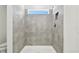 Clean shower with gray tile surround and window at 10536 Hidden Banks Gln, Parrish, FL 34219