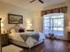 Bright bedroom with hardwood floors, large window, and comfortable bedding at 13417 Whitehaven Ct, Spring Hill, FL 34609