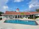 Community pool with adjacent clubhouse and lounge chairs at 13417 Whitehaven Ct, Spring Hill, FL 34609