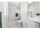 Bright bathroom featuring white tile, marble countertops, and a glass-enclosed shower and bathtub at 6030 Printery St # 105, Tampa, FL 33616