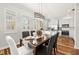 Bright dining room with large windows, hardwood floors, and an elegant light fixture adjacent to the kitchen at 6030 Printery St # 105, Tampa, FL 33616