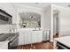 Bright kitchen featuring stainless steel appliances, white cabinetry and backsplash, and dark wood flooring at 6030 Printery St # 105, Tampa, FL 33616