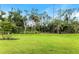 Green grassy backyard with mature trees at 1877 Pepper Grass Dr, North Port, FL 34289