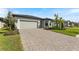 New construction home with gray siding, paver driveway and a two-car garage at 1877 Pepper Grass Dr, North Port, FL 34289