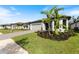 Modern home with gray siding, paver driveway, and a landscaped yard at 1877 Pepper Grass Dr, North Port, FL 34289