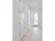 Bright hallway with white walls and light wood-look tile flooring at 1877 Pepper Grass Dr, North Port, FL 34289