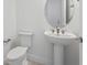 Modern powder room with pedestal sink and round mirror at 1877 Pepper Grass Dr, North Port, FL 34289