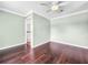 Simple bedroom with dark hardwood floors and ceiling fan at 12731 Timber Run, Dade City, FL 33525