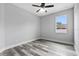 A bedroom with modern gray floors, ceiling fan, and a bright window overlooking the neighborhood at 2724 W Dewey St, Tampa, FL 33607