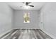Neutral bedroom with ceiling fan, window with backyard view, and a white paneled door at 2724 W Dewey St, Tampa, FL 33607
