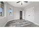 Bright bedroom with a large window, ceiling fan, and modern gray flooring at 2724 W Dewey St, Tampa, FL 33607