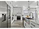 Modern kitchen featuring stainless steel appliances, white cabinetry, farmhouse sink and stone countertops at 2724 W Dewey St, Tampa, FL 33607