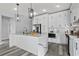 Bright kitchen features stainless appliances, white cabinets, stone countertops, and island with bar seating at 2724 W Dewey St, Tampa, FL 33607
