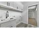 Well-lit laundry room features modern cabinets, sink, and direct access to the garage at 2724 W Dewey St, Tampa, FL 33607