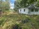 Small house with overgrown yard at 1716 Lancelot Loop, Tampa, FL 33619