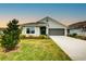 One-story house with gray siding, teal door, and a two-car garage at 7030 162Nd E Pl, Parrish, FL 34219