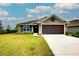 House exterior featuring a two-car garage and landscaped lawn at 7014 162Nd Place E. E Pl, Parrish, FL 34219