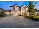 Two-story home with a three-car garage and a paver driveway at 33346 Kateland Dr, Wesley Chapel, FL 33545