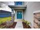 Inviting front entrance with teal door, stone accents, and landscaped walkway at 16123 69Th E Ln, Parrish, FL 34219
