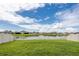 Green grassy backyard with white fence and pond view at 5429 Blue Azure Dr, Wimauma, FL 33598