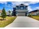 Two-story blue house with gray garage and landscaping at 6931 162Nd E Pl, Parrish, FL 34219