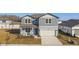 Two-story house with gray siding, white garage door, and landscaped lawn at 1268 Kazaz Ct, Zephyrhills, FL 33540
